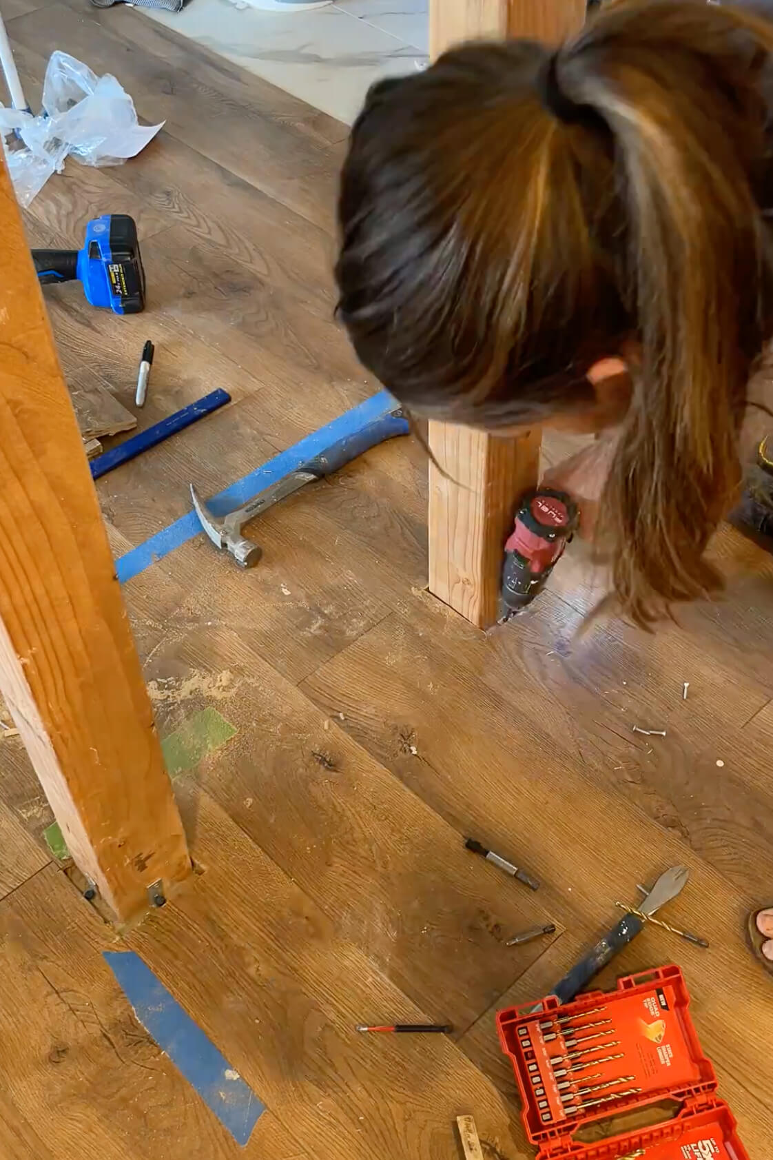 Attaching an island leg to the kitchen floor.